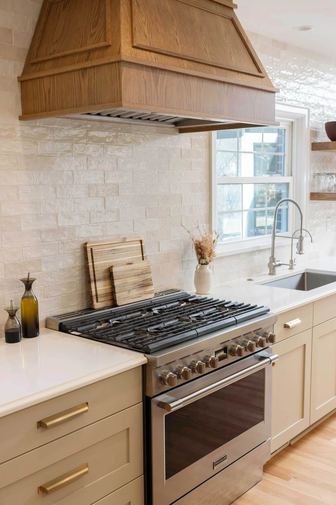 Balding Design Build custom home kitchen with gas range and wood vent hood in Wilmington, NC