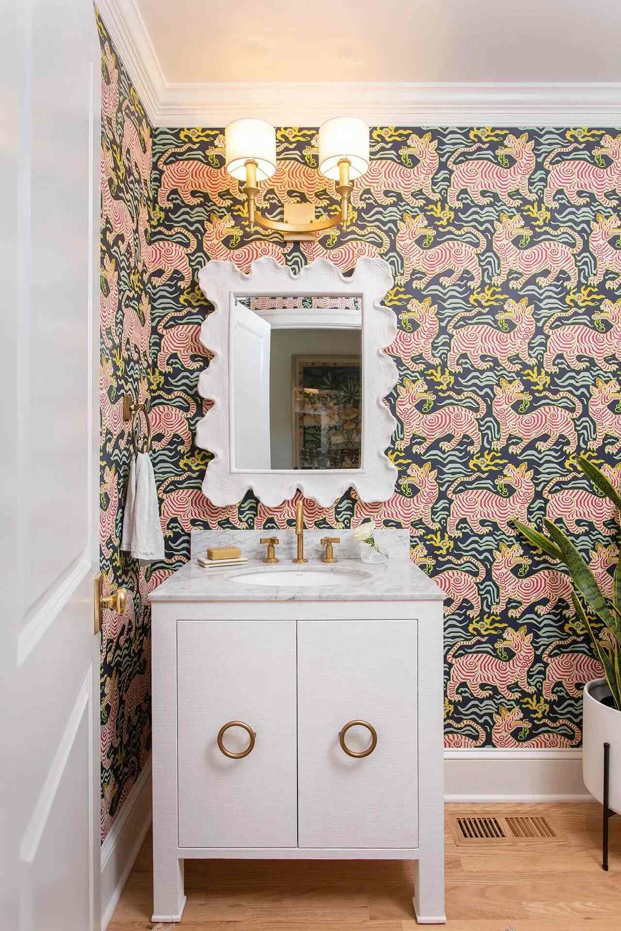 Bold powder room with eclectic wallpaper and gold fixtures designed by Balding Design Build in Wilmington, NC