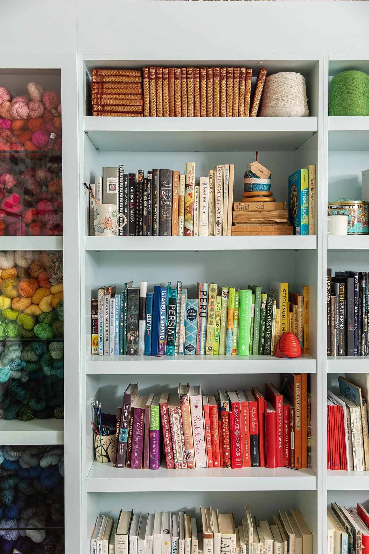 Built-in bookshelves with colorful books and yarn storage in a Wilmington, NC custom home by Balding Design Build