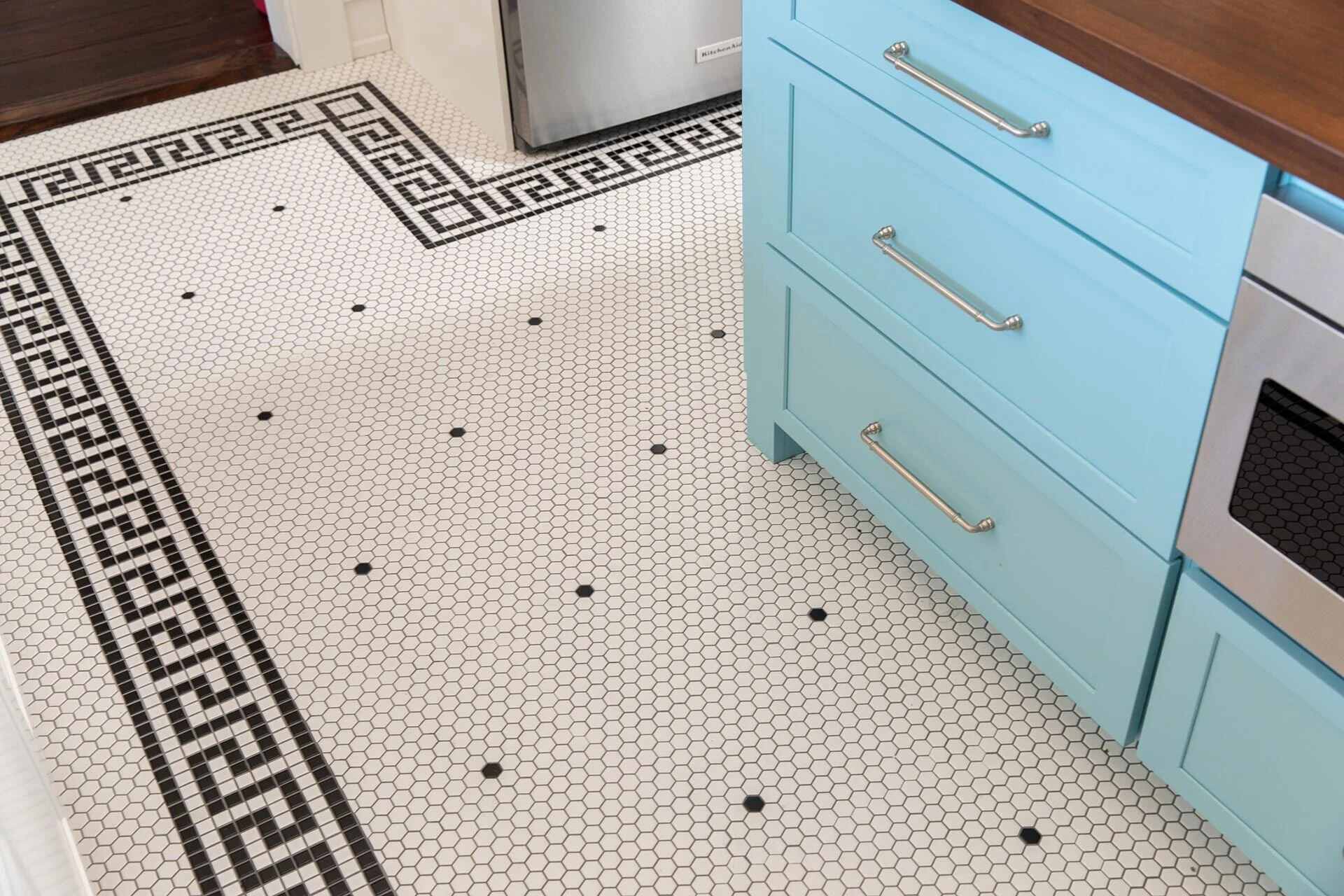 Close-up of hexagonal mosaic tile flooring with black and white detailing in a custom kitchen by Balding Design Build in Wilmington, NC