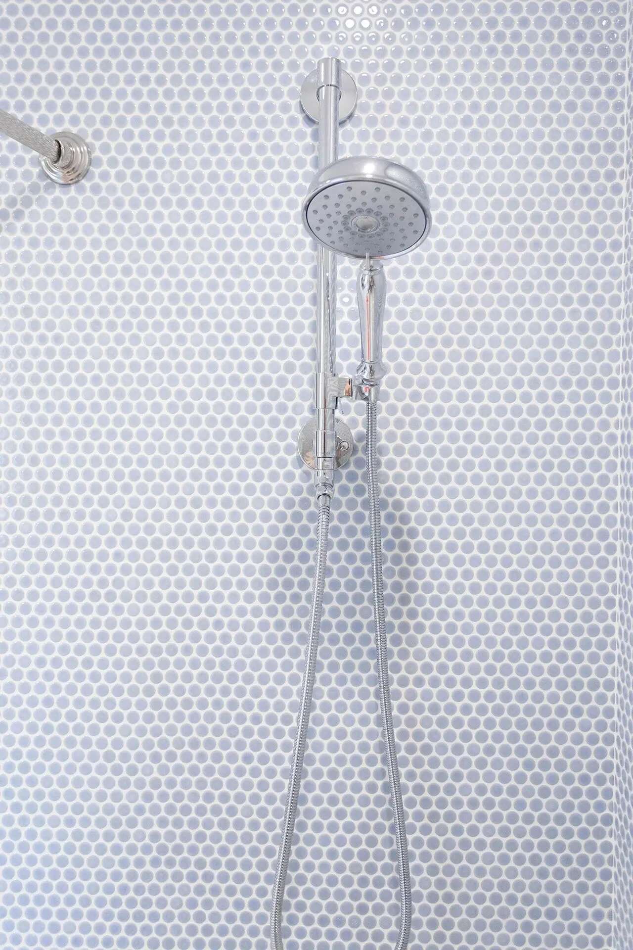 Custom shower remodel with penny tile wall and chrome fixtures by Balding Design Build in Wilmington, NC