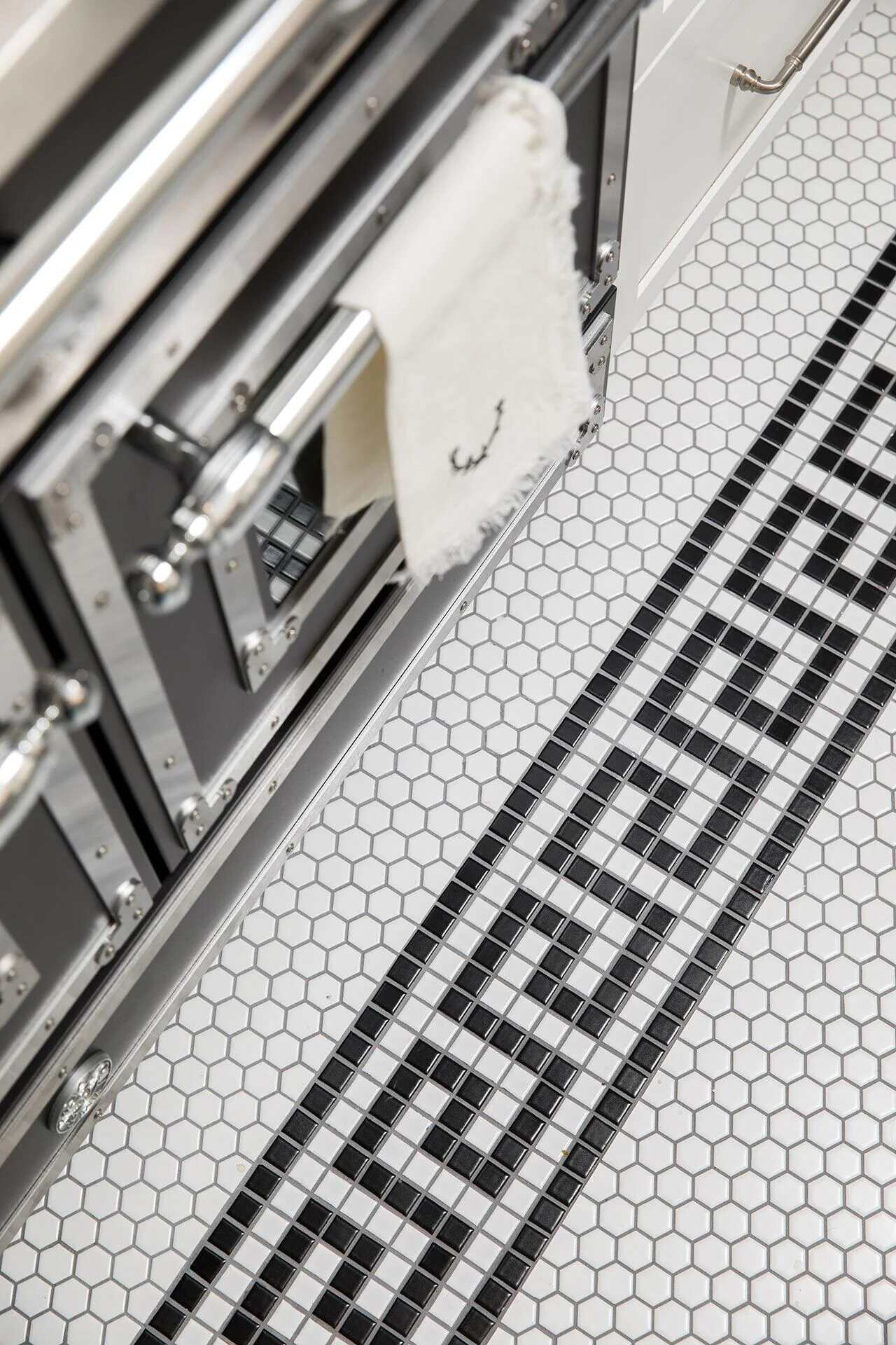 Detailed view of black and white mosaic tile border in custom kitchen flooring by Balding Design Build in Wilmington, NC