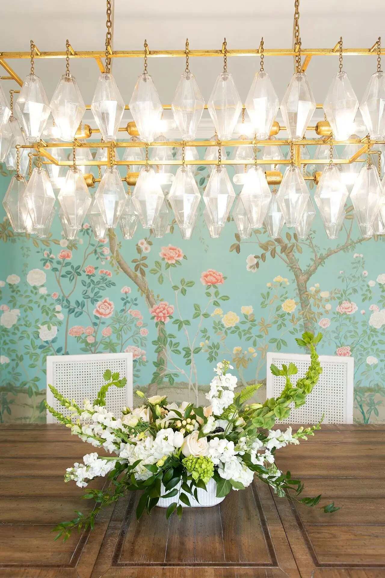 Dining room with floral wallpaper and crystal chandelier in a custom home by Balding Design Build in Wilmington, NC