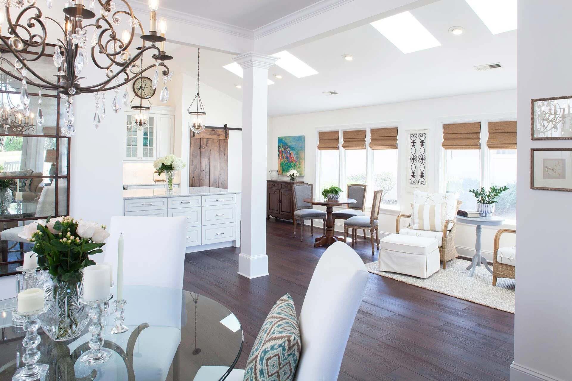 Elegant open-concept living and dining area with white cabinetry and dark wood floors by Balding Design Build in Wilmington, NC