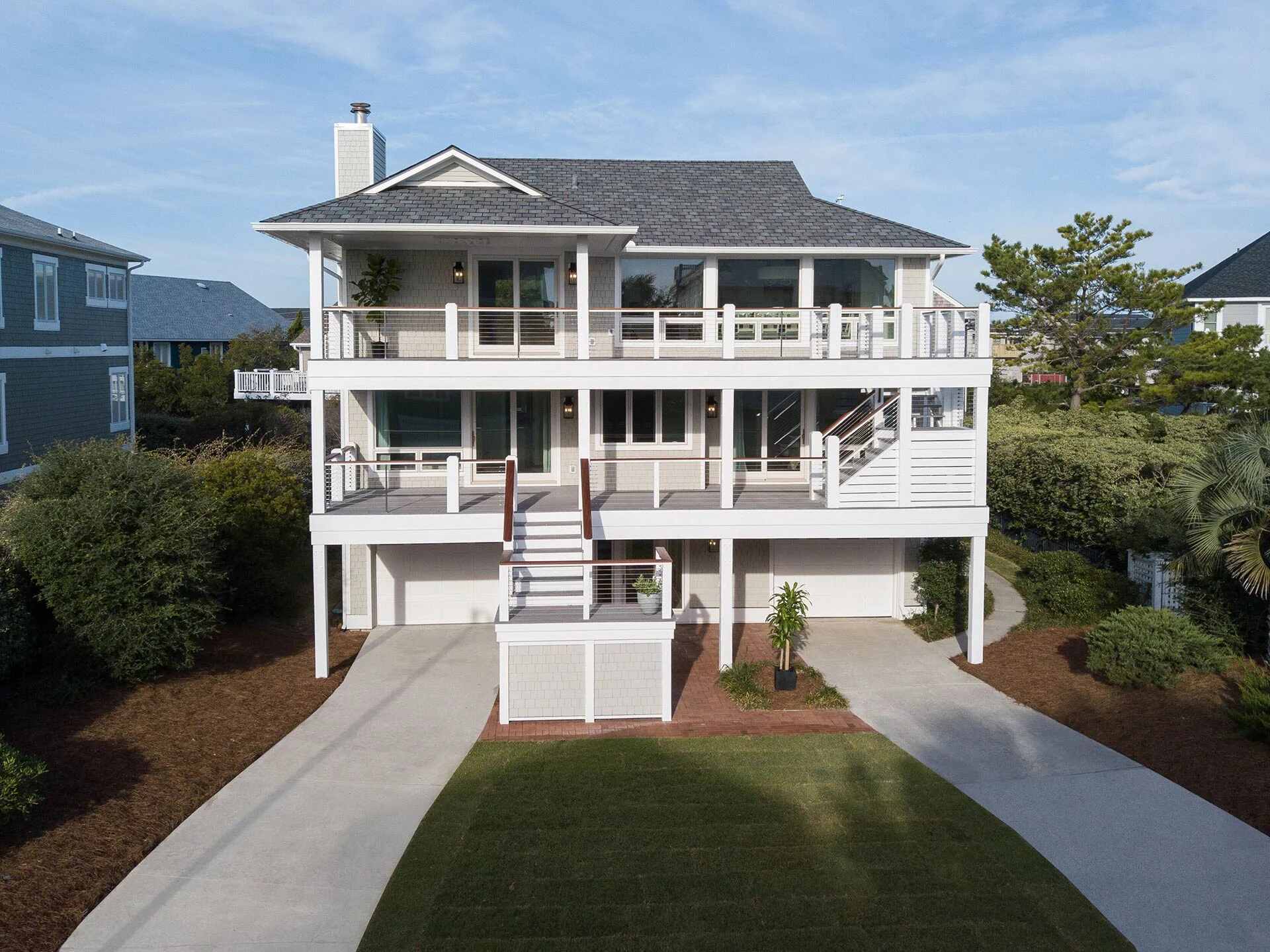 Front exterior of a three-story coastal custom home by Balding Design Build in Wilmington, NC