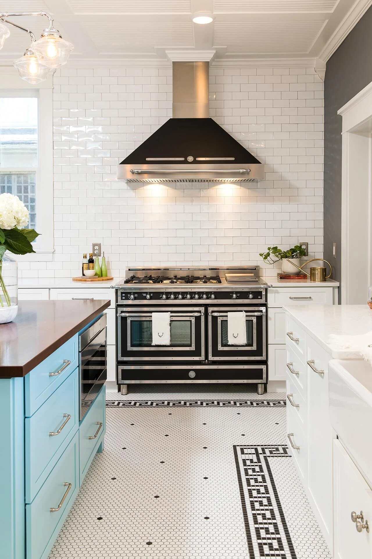 High-end custom kitchen with double oven range and white tile backsplash by Balding Design Build in Wilmington, NC.