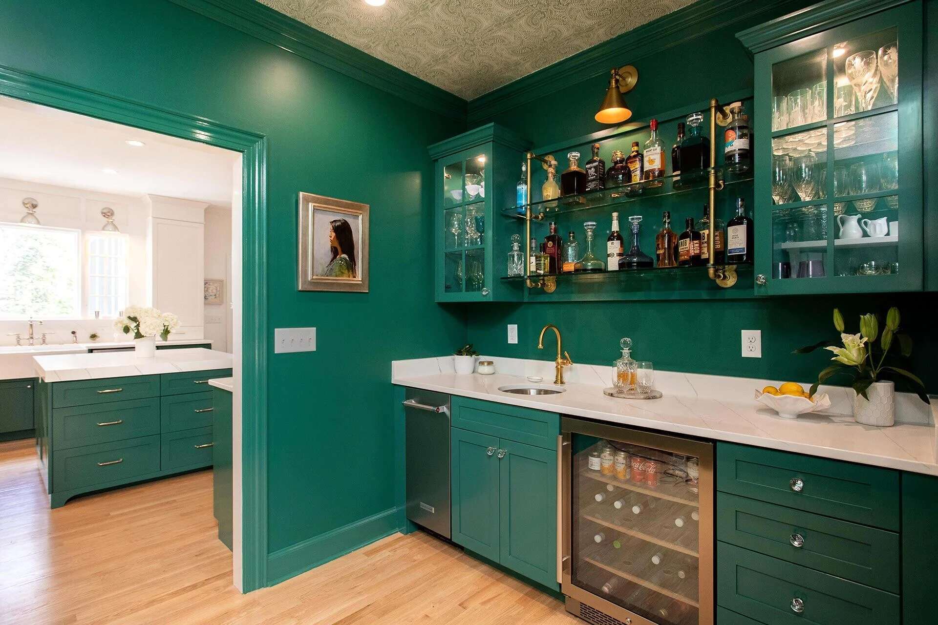 Home bar with glass shelving, brass accents, and green cabinetry in a Wilmington, NC custom home by Balding Design Build