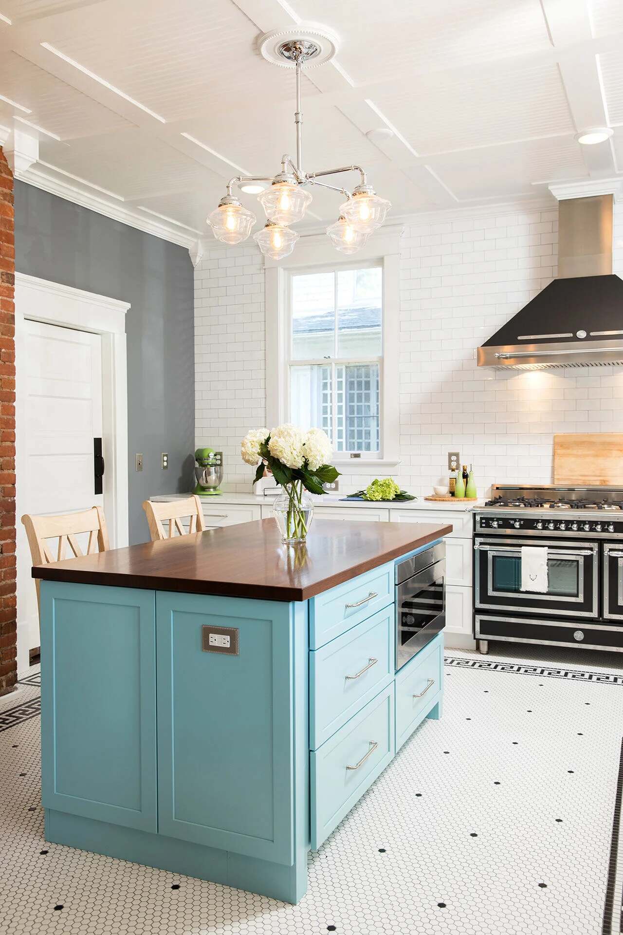 Kitchen island with powder blue cabinetry and wood countertop in a Wilmington, NC custom home by Balding Design Build