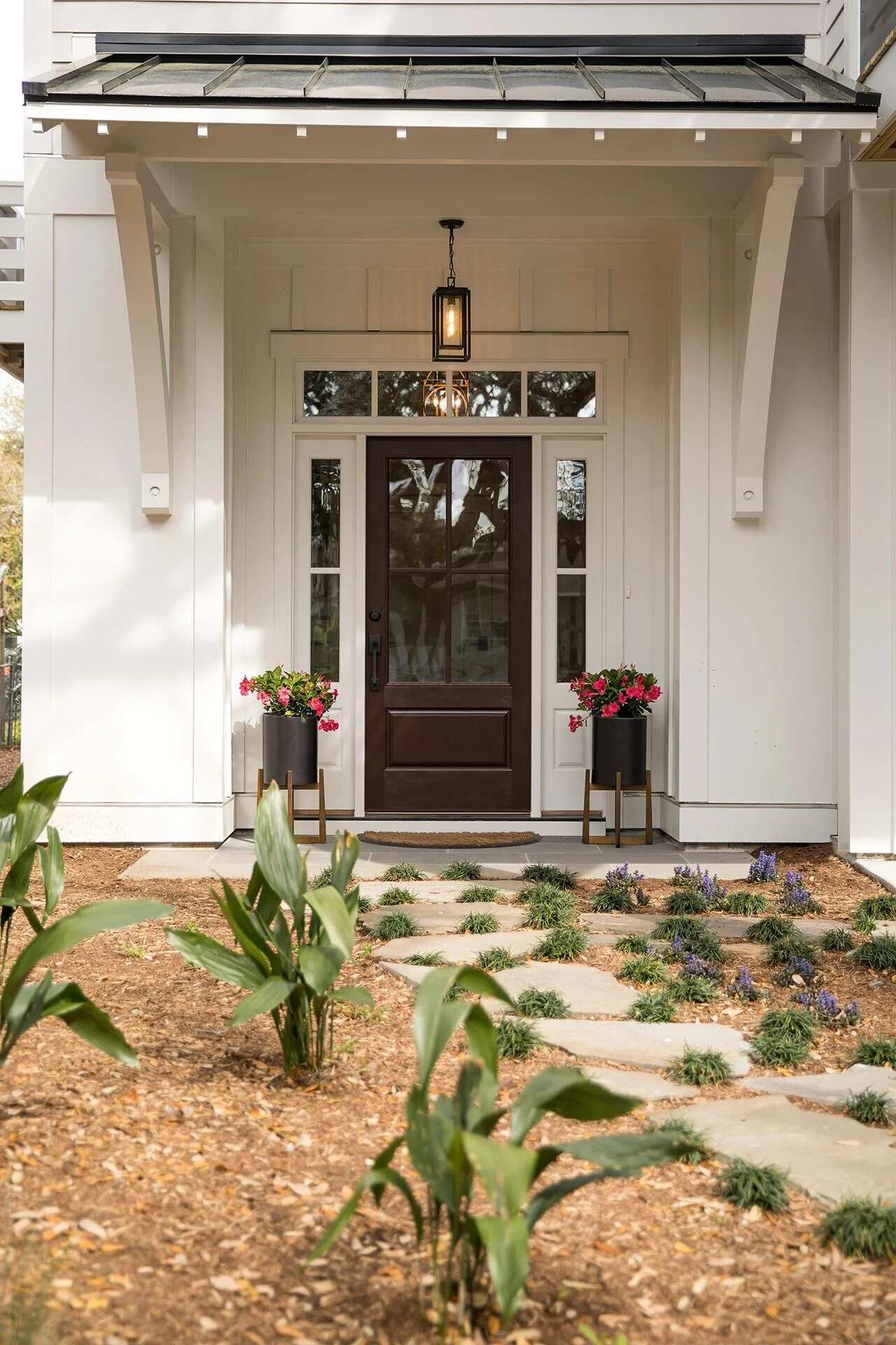 Modern front entry with dark wood door and white siding in a Wilmington, NC custom home by Balding Design Build