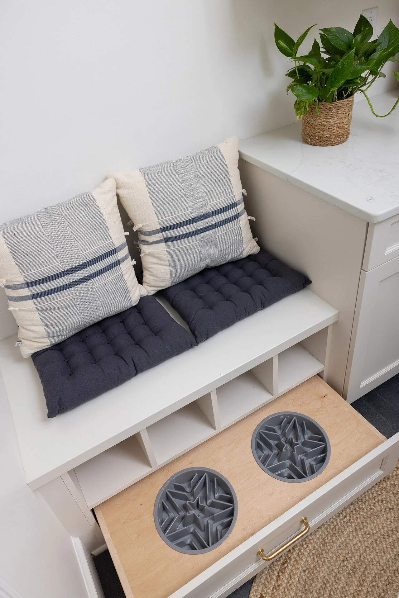 Mudroom pet station with integrated food bowls and cozy seating in a Balding Design Build home near Greenville Loop Area, NC