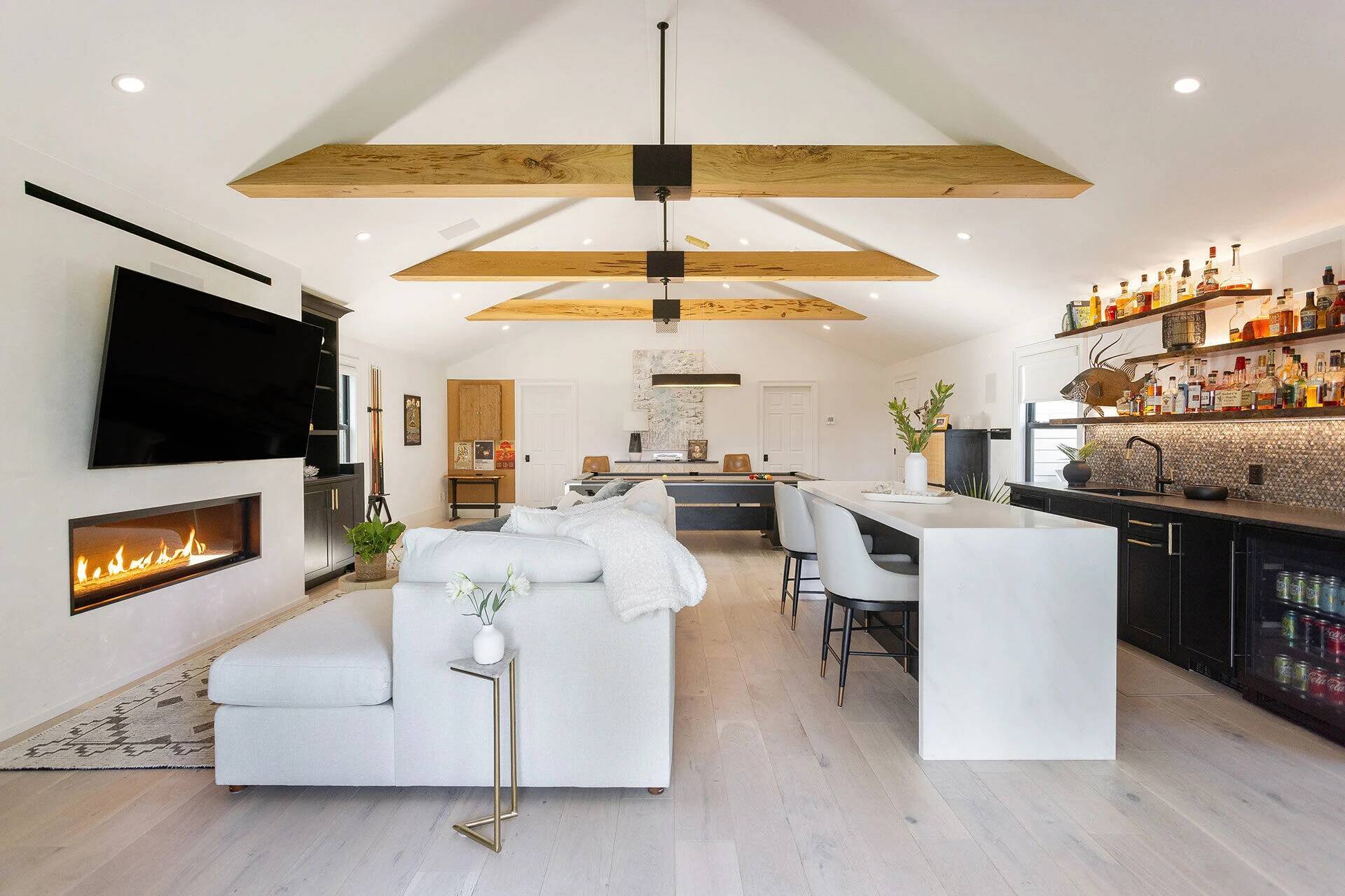 Open-concept living room with vaulted ceiling and exposed beams in a custom home by Balding Design Build in Wilmington, NC