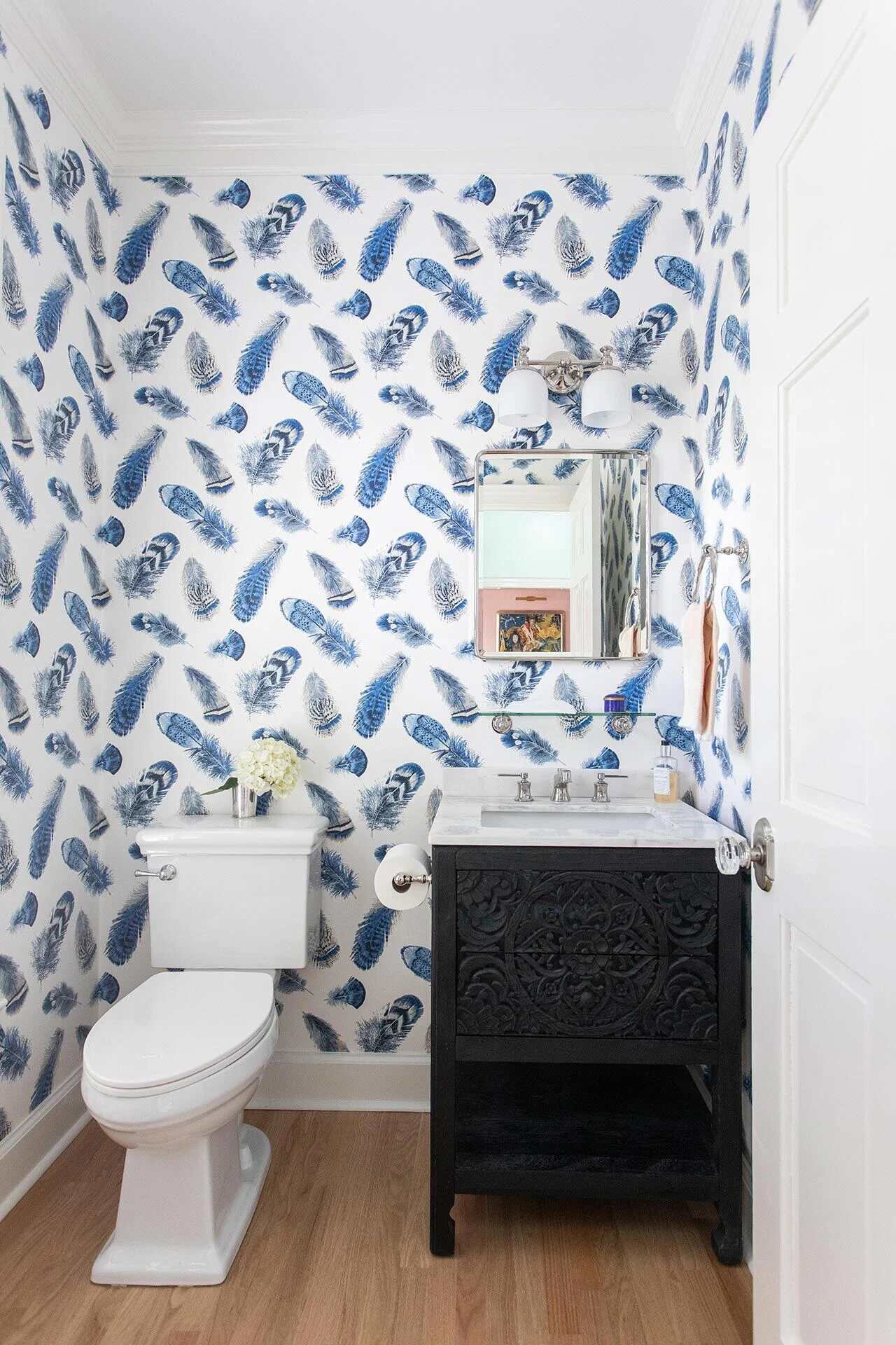 Powder room with bold blue feather wallpaper and black vanity in a custom Wrightsville Beach, NC home by Balding Design Build