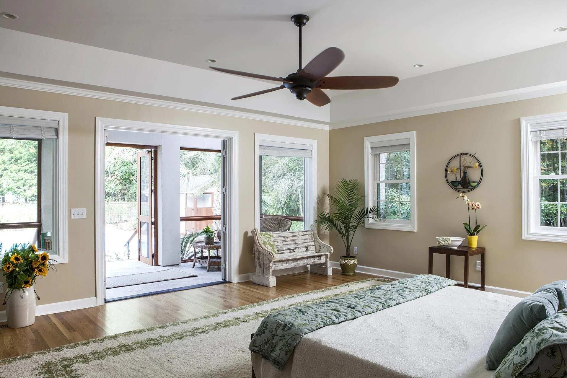 Primary bedroom with neutral tones and outdoor access in a custom home by Balding Design Build in Wilmington, NC