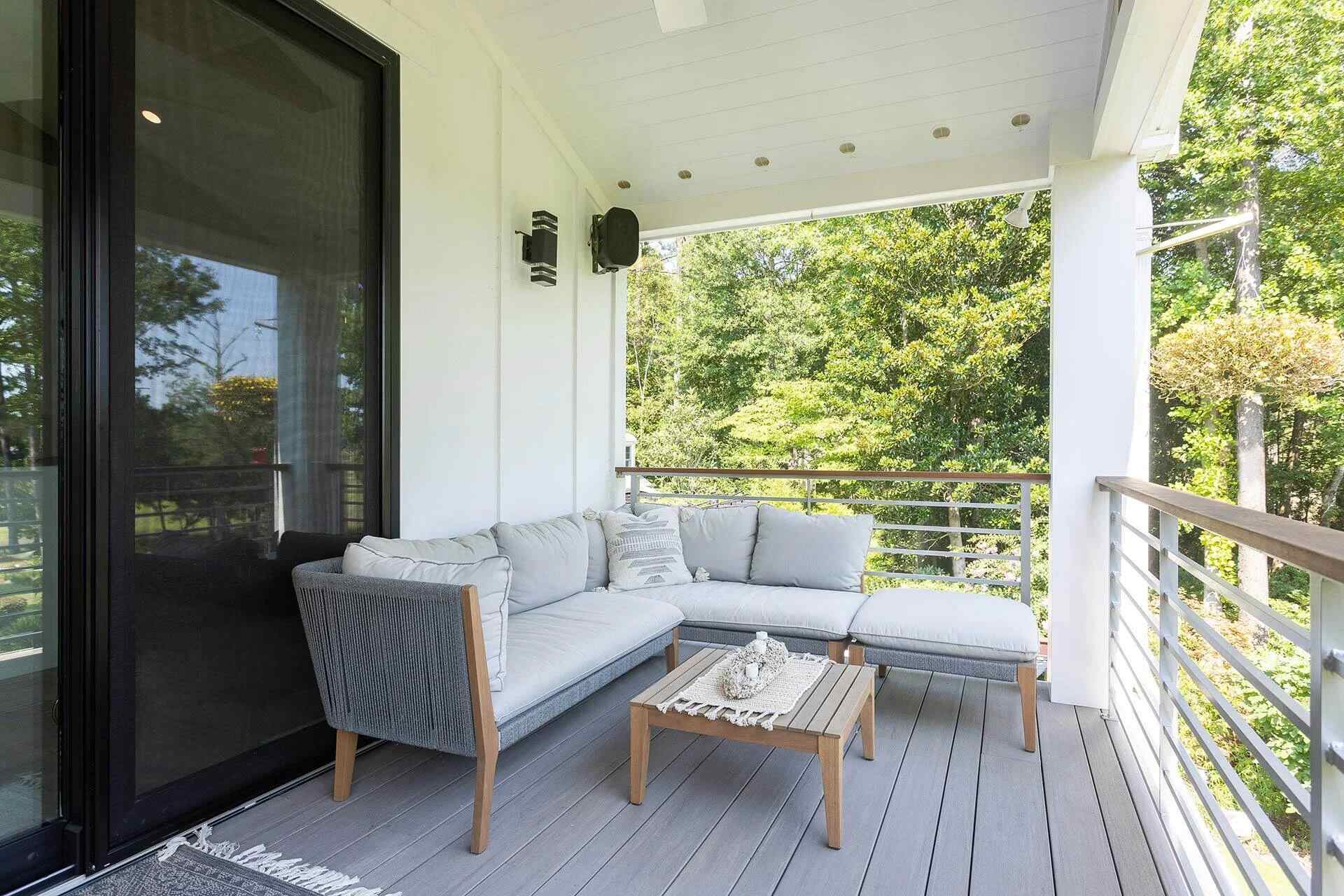 Scenic porch retreat with modern railing and treetop views by Balding Design Build in Wilmington, NC