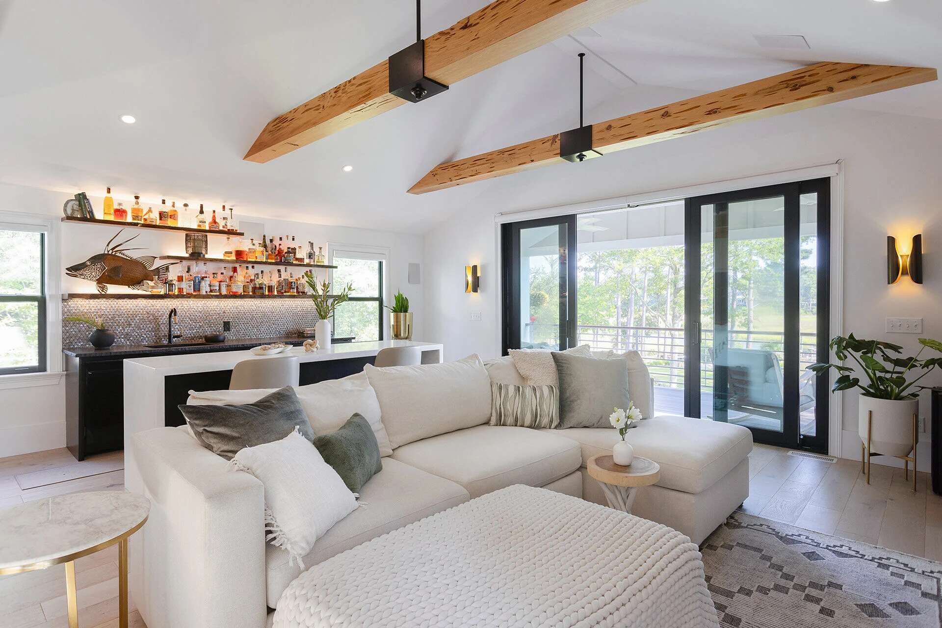 Wilmington, NC luxury custom home featuring wood beams, built-in bar, and sectional sofa by Balding Design Build