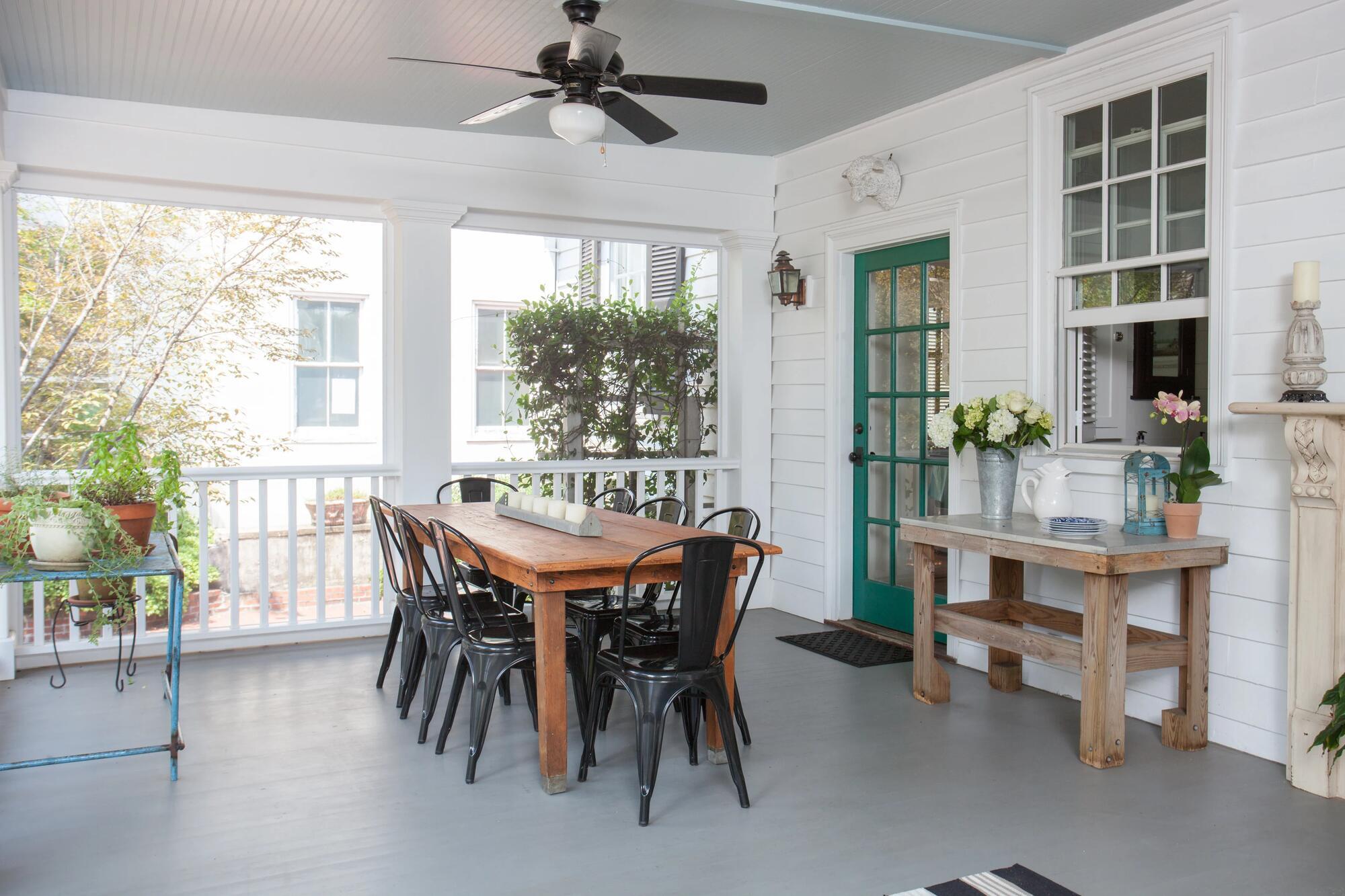 Covered outdoor patio with black metal chairs and farmhouse décor by Balding Design Build in Historic Downtown Wilmington, NC